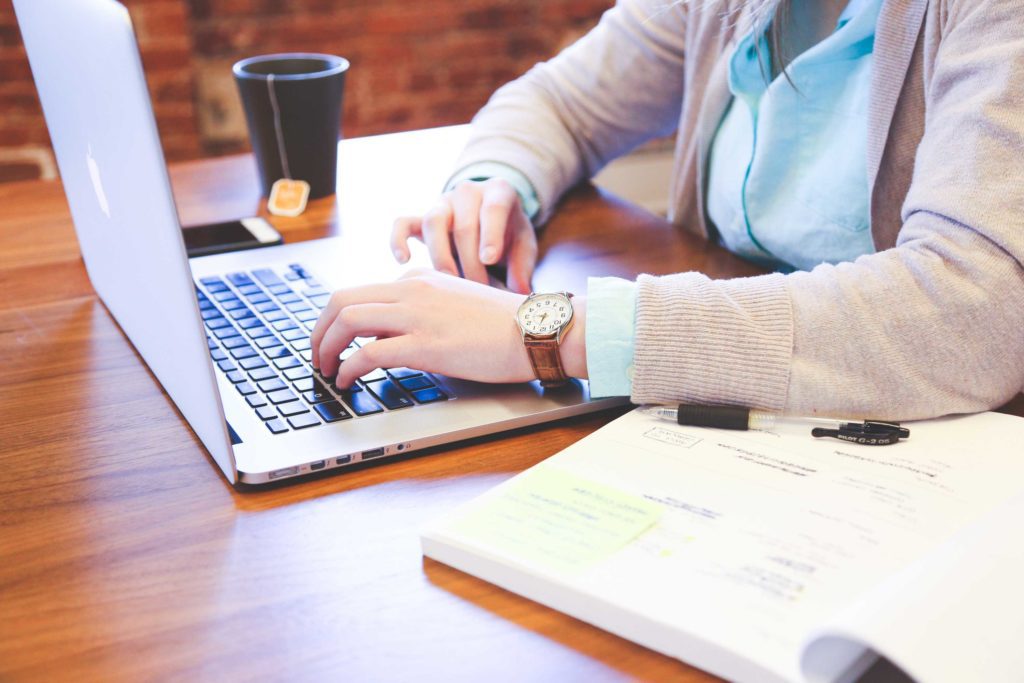 man with grey sweater working on computer
