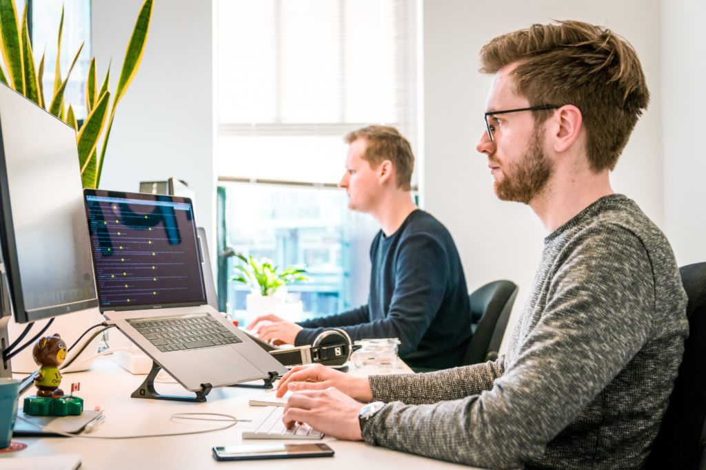 two men working on laptop